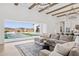 Bright, open living room featuring a large sectional sofa, wood beams, and access to the backyard at 19910 E Vallejo St, Queen Creek, AZ 85142