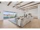 Expansive living room with a large sectional sofa, wood beam ceiling, and hardwood floors at 19910 E Vallejo St, Queen Creek, AZ 85142