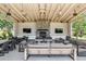 Spacious outdoor lounge area with a stone fireplace, TV, and comfortable seating for year-round enjoyment at 19910 E Vallejo St, Queen Creek, AZ 85142