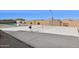 Spacious sport court featuring basketball hoop and tennis net with a swimming pool in the background at 19910 E Vallejo St, Queen Creek, AZ 85142