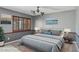 Staged bedroom features neutral carpet, two-tone gray walls, a bed and wooden shuttered windows at 2053 W Natal Cir, Mesa, AZ 85202