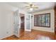 Bedroom has an open french door to an entryway, hardwood floors, ceiling fan, and window at 2053 W Natal Cir, Mesa, AZ 85202