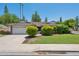 Charming single-story home featuring a well-manicured lawn, mature trees, and a two-car garage with a light brown roof at 2053 W Natal Cir, Mesa, AZ 85202
