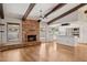 Bright living room open to kitchen, with hardwood floors, brick fireplace and white cabinetry at 2053 W Natal Cir, Mesa, AZ 85202