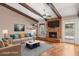 Staged living room with wood beams, brick fireplace, hardwood floors, and modern decor at 2053 W Natal Cir, Mesa, AZ 85202