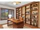 Home office features wooden desk, built-in shelves filled with books and accessories at 2053 W Natal Cir, Mesa, AZ 85202