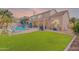 Expansive backyard featuring a swimming pool, outdoor kitchen, grassy area, and patio furniture at 20809 N 17Th St, Phoenix, AZ 85024
