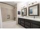 Bright bathroom with dual sinks, dark wood cabinets, tub and shower combo at 20809 N 17Th St, Phoenix, AZ 85024