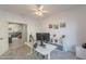 Home office with a ceiling fan, white desk, wall decor, and view of the stairwell at 20809 N 17Th St, Phoenix, AZ 85024