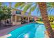 Backyard with a pool, built-in barbeque, palm trees, lounge chairs, and a covered patio at 20809 N 17Th St, Phoenix, AZ 85024