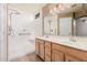 Bathroom with double sink vanity, large mirror and walk-in shower with grab bars at 3343 W Lone Cacuts Dr, Phoenix, AZ 85027