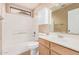 Bright bathroom features a tub with a shower, cabinet, and a sink with a wooden cabinet at 3343 W Lone Cacuts Dr, Phoenix, AZ 85027