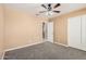 Bedroom featuring a ceiling fan, carpeted floor and adjacent access to bathroom at 3343 W Lone Cacuts Dr, Phoenix, AZ 85027
