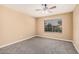 A cozy bedroom boasts neutral colors, a ceiling fan and a window for natural light at 3343 W Lone Cacuts Dr, Phoenix, AZ 85027