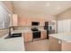 Well-lit kitchen features stainless steel appliances, light wood cabinets, and tile flooring at 3343 W Lone Cacuts Dr, Phoenix, AZ 85027