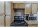 Kitchen features tile countertops, wood cabinets, oven, and stainless steel microwave at 3347 W Roma Ave, Phoenix, AZ 85017