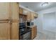Spacious kitchen with wooden cabinets, black oven, microwave, and tile flooring for easy maintenance at 3347 W Roma Ave, Phoenix, AZ 85017