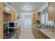 Well-lit kitchen featuring tile countertops and floors, stainless steel sink, and ample wooden cabinetry at 3347 W Roma Ave, Phoenix, AZ 85017