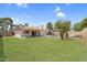 Grassed backyard with a covered patio and a swimming pool in ground at 3514 W Helena Dr, Glendale, AZ 85308