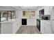 Bright kitchen features white cabinets, countertops, and modern appliances and a view of the back yard pool at 3514 W Helena Dr, Glendale, AZ 85308