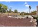Clean, fenced backyard pool with rock landscaping and blue skies above at 3514 W Helena Dr, Glendale, AZ 85308