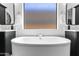 Luxurious bathroom with a freestanding tub, double vanities, and a bright window at 3890 E Andalusia Ave, Gilbert, AZ 85298