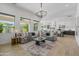 Bright, open-concept living room showcases large windows, modern furnishings, and seamless flow to the kitchen at 3890 E Andalusia Ave, Gilbert, AZ 85298