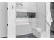 Modern tiled shower with frameless glass door, bench, and a rainfall shower head at 3890 E Andalusia Ave, Gilbert, AZ 85298