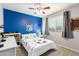 Bright bedroom featuring light grey walls and a blue accent wall with sporty soccer themed decor at 40316 W Hopper Dr, Maricopa, AZ 85138