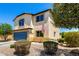 Lovely two-story home featuring a blue garage door, manicured landscaping, and charming curb appeal at 40316 W Hopper Dr, Maricopa, AZ 85138