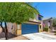 Well-maintained two-story home with a blue garage door, tidy landscaping, and an inviting curb appeal at 40316 W Hopper Dr, Maricopa, AZ 85138