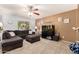 Comfortable living room featuring a gray sectional sofa, ceiling fan, and a decorative fish tank at 40316 W Hopper Dr, Maricopa, AZ 85138