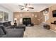 Comfortable living room featuring a gray sectional sofa, ceiling fan, and a decorative fish tank at 40316 W Hopper Dr, Maricopa, AZ 85138
