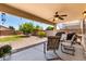 Inviting covered patio with ceiling fan, outdoor seating, BBQ, and a view of the landscaped backyard at 40316 W Hopper Dr, Maricopa, AZ 85138