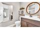 Bathroom with dark wood vanity, modern faucets, and a large round mirror above the sink at 4455 W Suncup Dr, San Tan Valley, AZ 85144