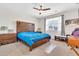 Comfortable bedroom with a large wooden headboard, ceiling fan, and a window providing natural light at 4455 W Suncup Dr, San Tan Valley, AZ 85144