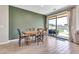 Bright dining area features a wooden table, modern flooring, and sliding glass doors to the outdoor pool area at 4455 W Suncup Dr, San Tan Valley, AZ 85144