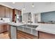 Island kitchen featuring a stainless steel farmhouse sink, dishwasher, and modern pendant lighting at 4455 W Suncup Dr, San Tan Valley, AZ 85144