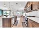 Gourmet kitchen featuring dark cabinets, large island, and modern appliances at 4455 W Suncup Dr, San Tan Valley, AZ 85144