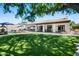 Expansive backyard with manicured lawn, covered patio, pool and lounge area for outdoor living at 4507 E Duane Ln, Cave Creek, AZ 85331