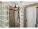 Luxurious tiled shower with glass block partition, rainfall showerhead, and door to bathroom at 4507 E Duane Ln, Cave Creek, AZ 85331