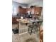 A cozy kitchen boasts wood cabinets, pendant lights, an island with bar seating, and tile floors at 4778 E Sourwood Dr, Gilbert, AZ 85298
