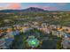 Scenic aerial view of the community pool and surrounding homes in the evening at 5100 E Rancho Paloma Dr # 1044, Cave Creek, AZ 85331