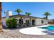 Charming backyard with a pool, covered patio, and lush greenery, ideal for relaxation and entertainment at 5211 E Winchcomb Dr, Scottsdale, AZ 85254