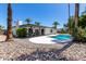 Beautiful backyard featuring a pristine pool, covered patio, and lush landscaping, perfect for outdoor enjoyment at 5211 E Winchcomb Dr, Scottsdale, AZ 85254