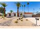 Charming white home with desert landscaping, red tiled roof and numerous palm trees at 5211 E Winchcomb Dr, Scottsdale, AZ 85254