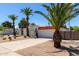Charming white home with desert landscaping, wrought iron gate and numerous palm trees at 5211 E Winchcomb Dr, Scottsdale, AZ 85254