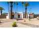 Charming white home with desert landscaping, red tiled roof and numerous palm trees at 5211 E Winchcomb Dr, Scottsdale, AZ 85254