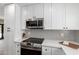 Close up of the updated kitchen with stainless appliances, stylish backsplash, and sleek white cabinets at 5211 E Winchcomb Dr, Scottsdale, AZ 85254