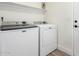 Modern laundry room with front loading washer and dryer at 5211 E Winchcomb Dr, Scottsdale, AZ 85254